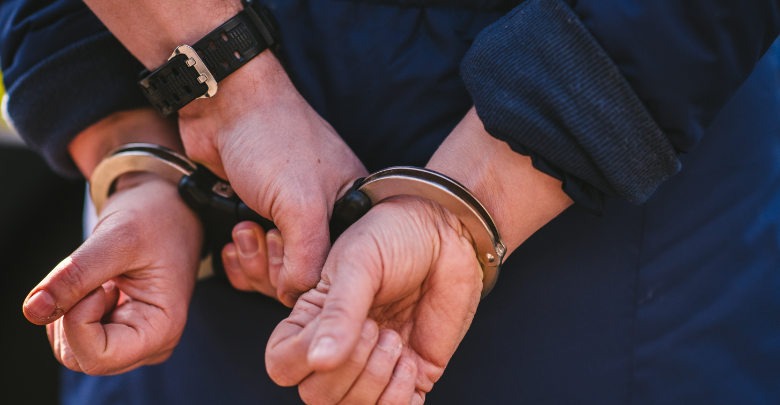 Hands in handcuffs behind their back