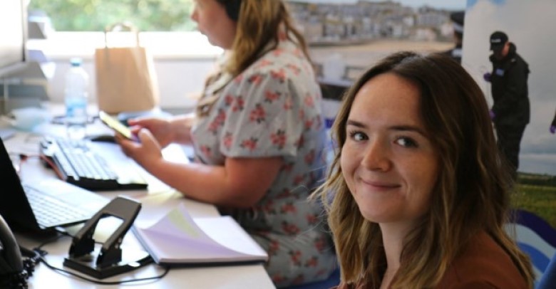 Smiling at camera while sat at desk