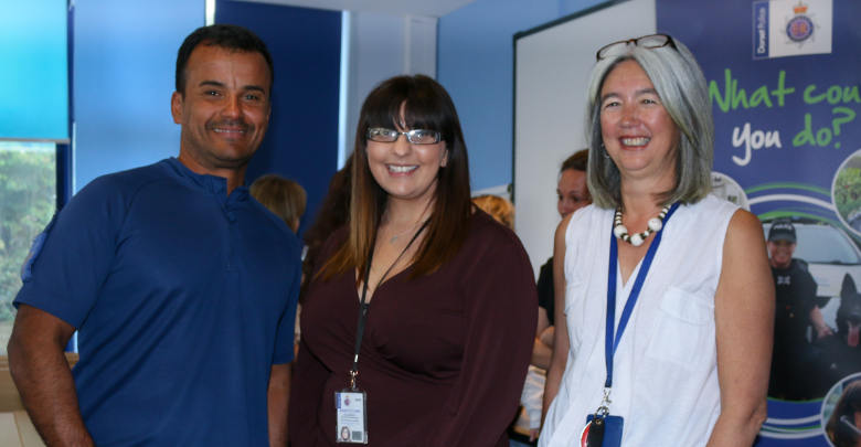Three staff members stood in front of a stand