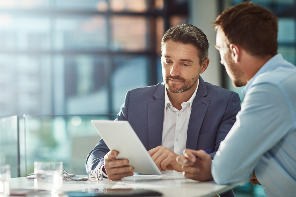 Two men talking and looking at a document