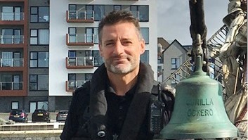 Jason Cooper in police marine unit uniform on police boat in Poole docks