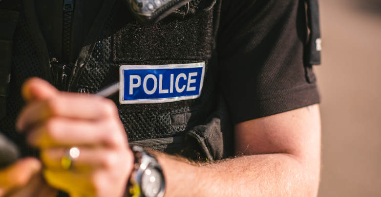 Close up of police office torso and hand writing to a note book