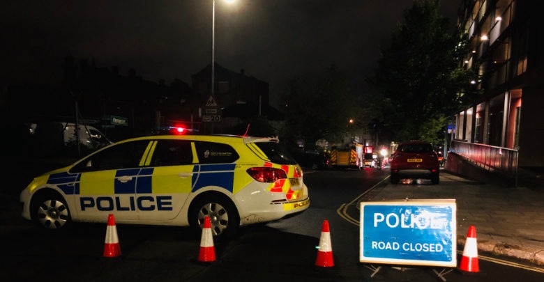 A police car on the street at night behind cones